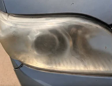 Before: a cloudy, yellowed headlight on a silver van